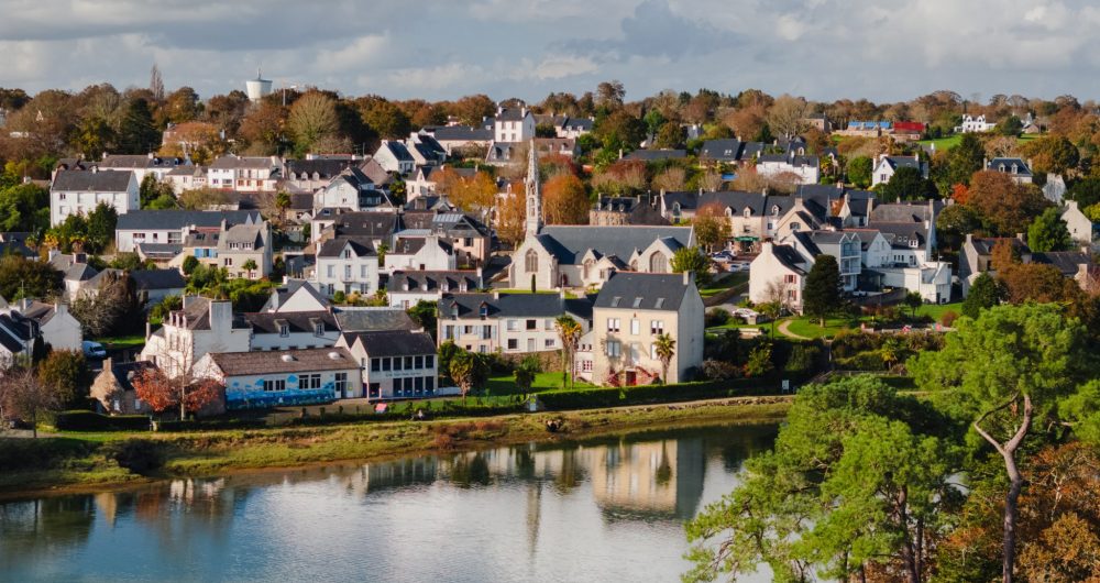 Le typique bourg de La Forêt-Fouesnant avec ses maisons blanches à toit d'ardoise et l'église au milieu et l'eau de l'anse de La Forêt